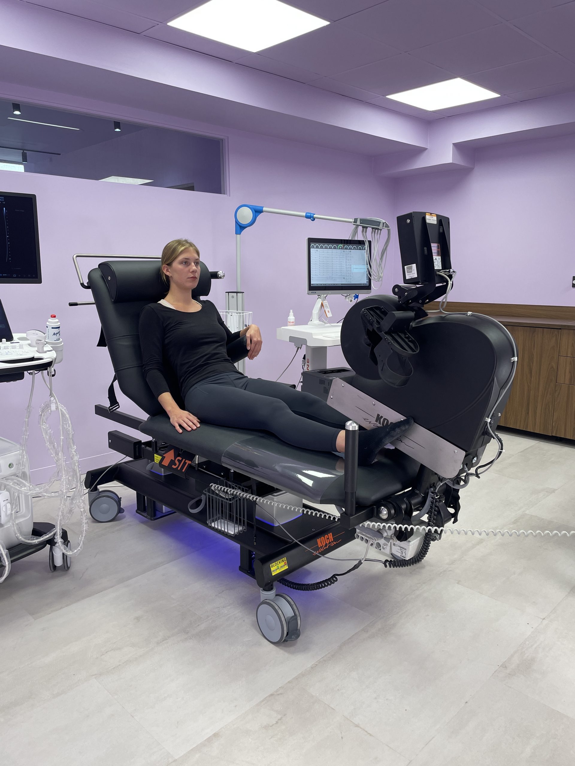 divan ergométrique d'échocardiographie en position repos avec un patient se maintenant au calage d'aisselle.